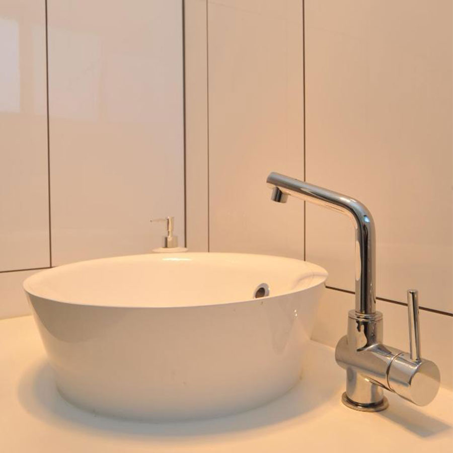 Modern bathroom with a sleek round sink and chrome faucet.